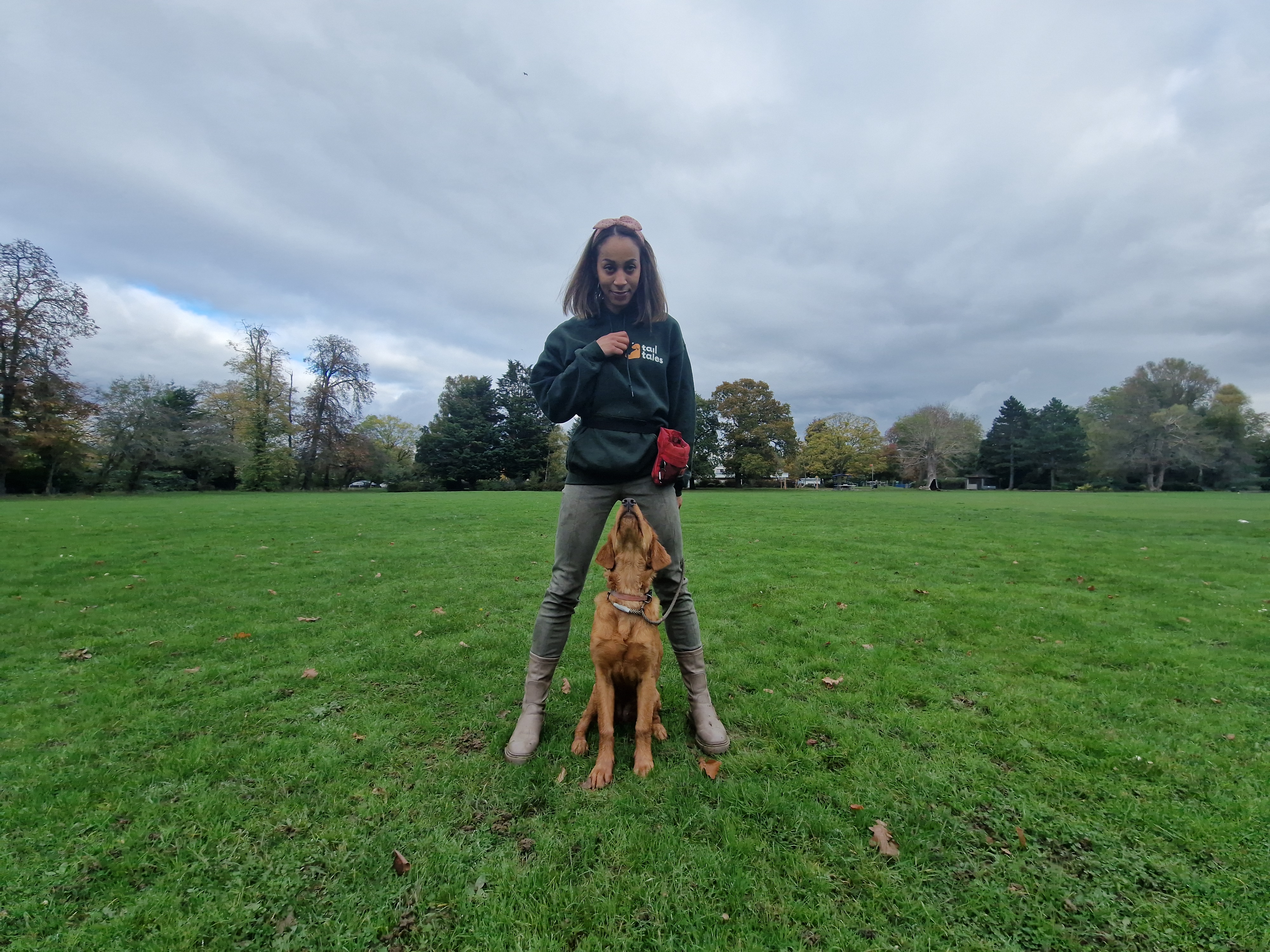 Gala practising positive reinforcement with a dog on grass
